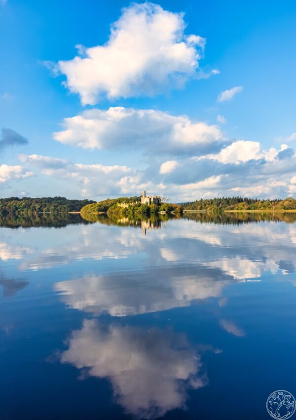 Bastion Blues A symmetrical reflection of McDermott's Castle on an island in Lough Key, County Roscommon, under a bright blue sky.